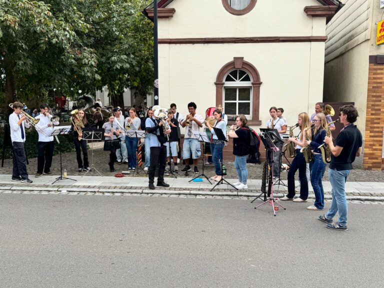 Die United Concert Band spielt am Rand der Hauptstraße in Herxheim.