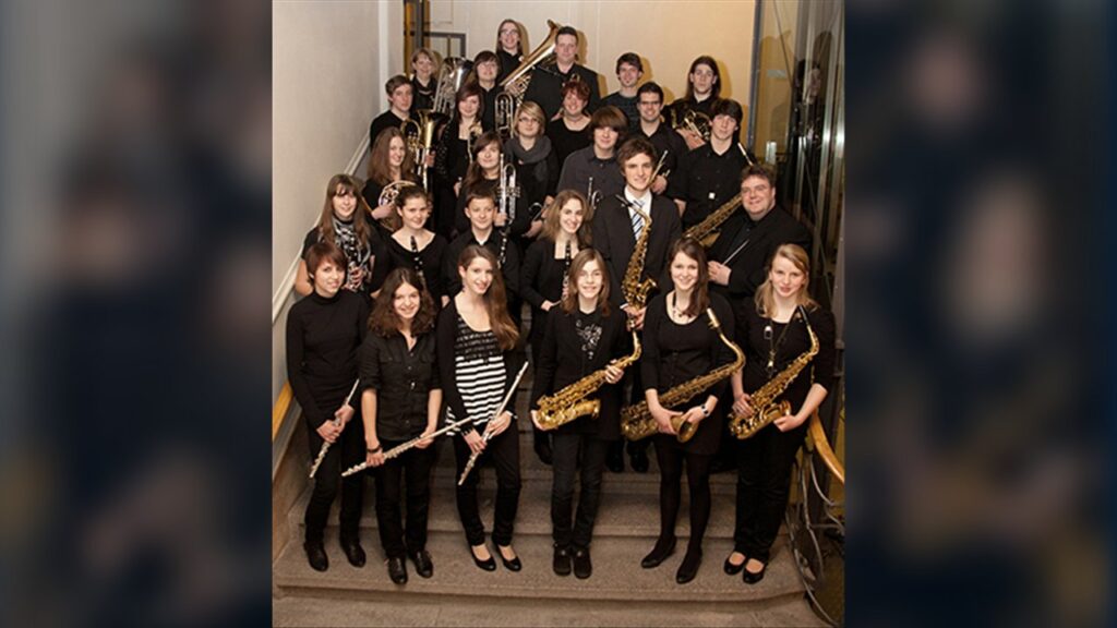 Das Jugendblasorchester der Stadtkapelle Landau im Jahr 2012: rund 30 junge Musikerinnen und Musiker mit ihren Instrumenten auf einer Treppe.